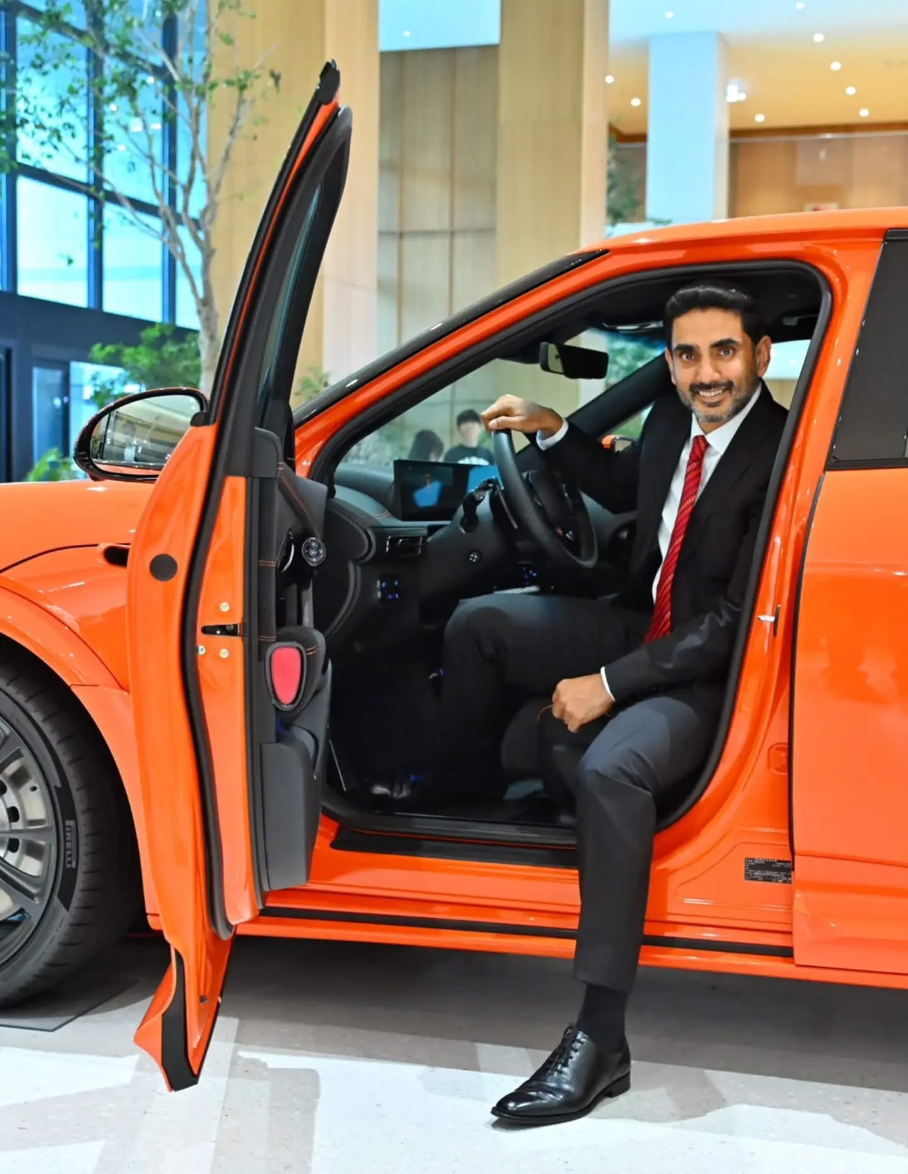 Nara Lokesh, Andhra Pradesh's minister for information technology, electronics and communications, real-time governance, and human resources development, poses for a photograph in a Kia vehicle during a visit to Kia headquarters in Seoul on Thursday. (Embassy of India in Seoul)