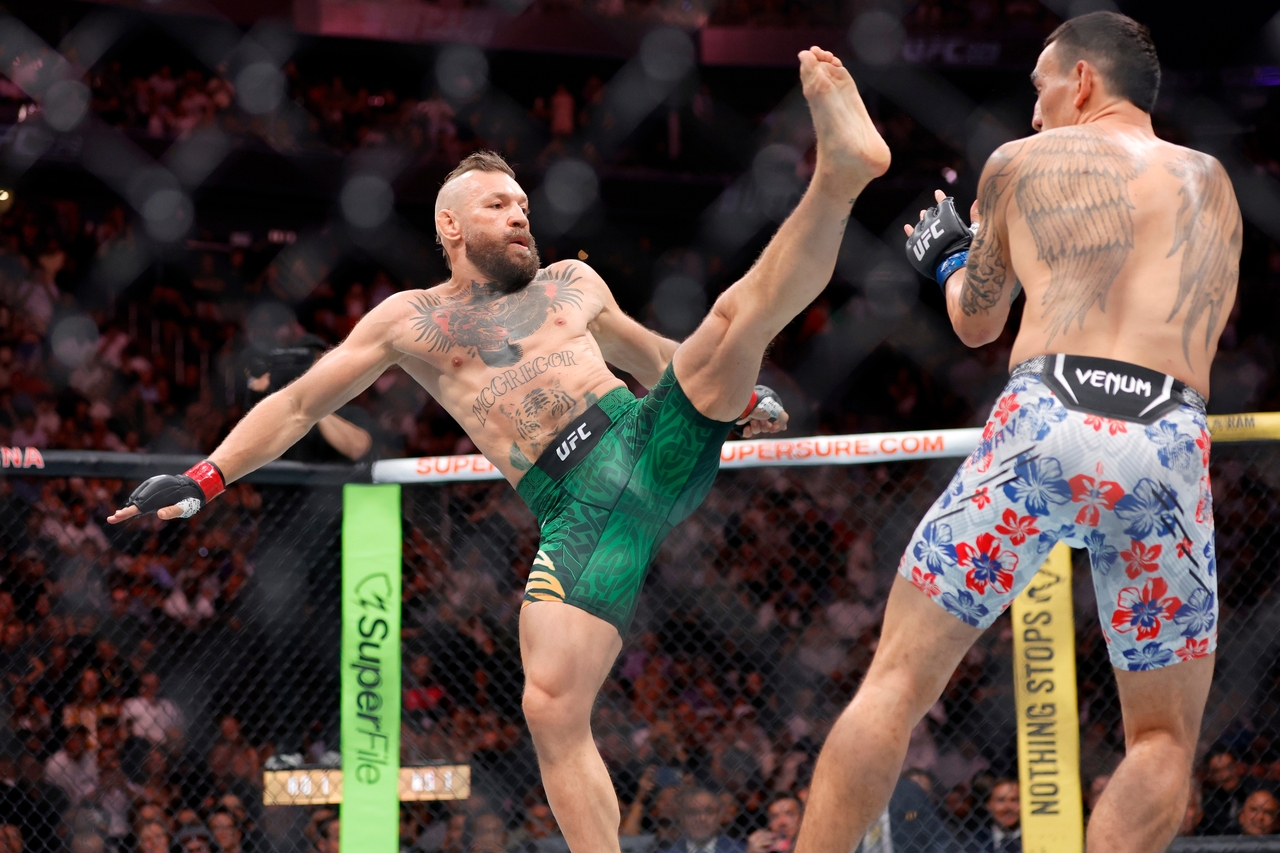 Conor McGregor (left) attacks Max Holloway with a kick at the start of a welterweight fight during UFC 329 in Las Vegas on Saturday.   AP-Yonhap