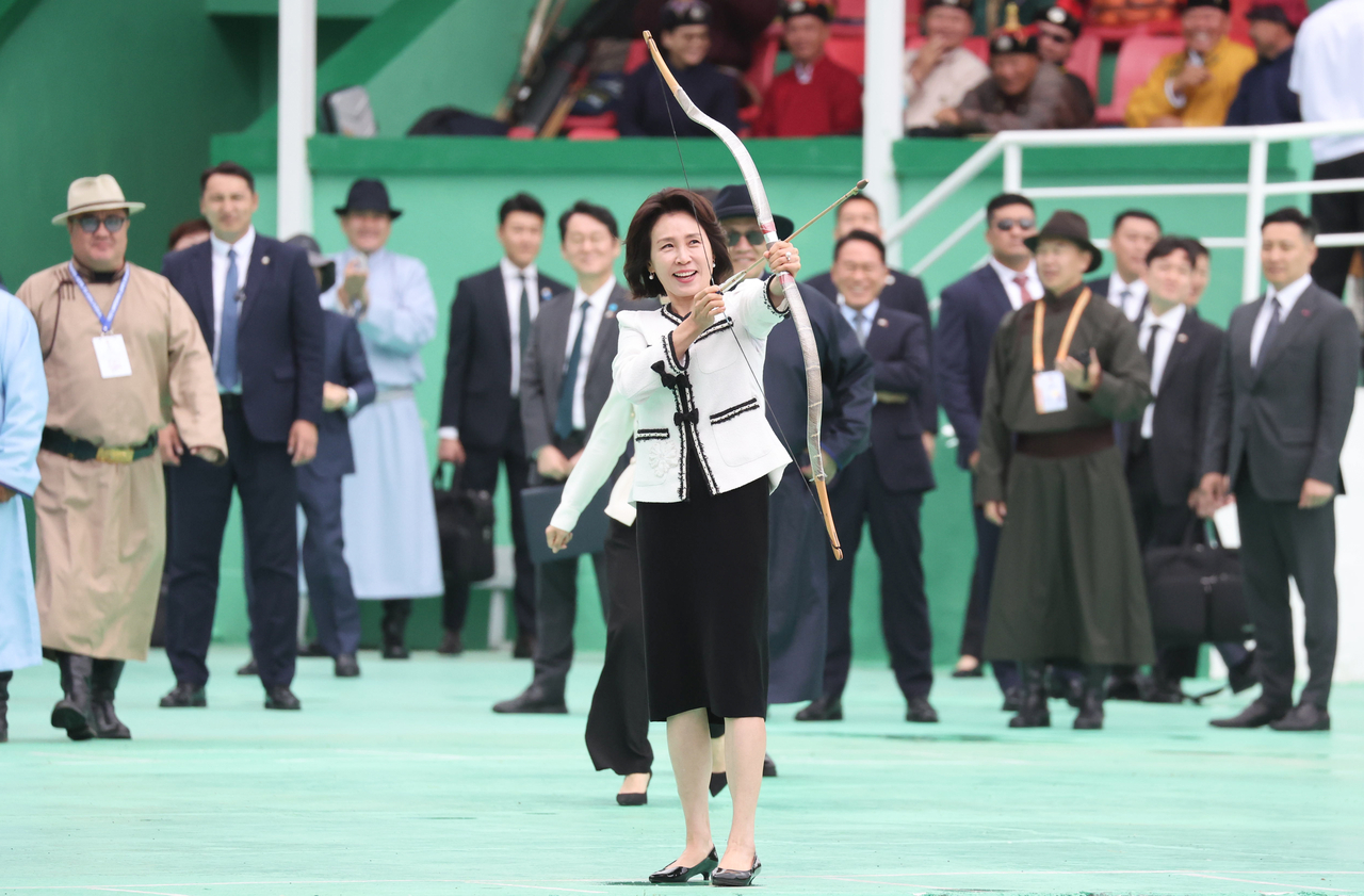 First Lady  Kim Hea  Kyung try traditional Mongolian archery during a visit to the Naadam Festival grounds in Ulaanbaatar on Saturday. (Yonhap)