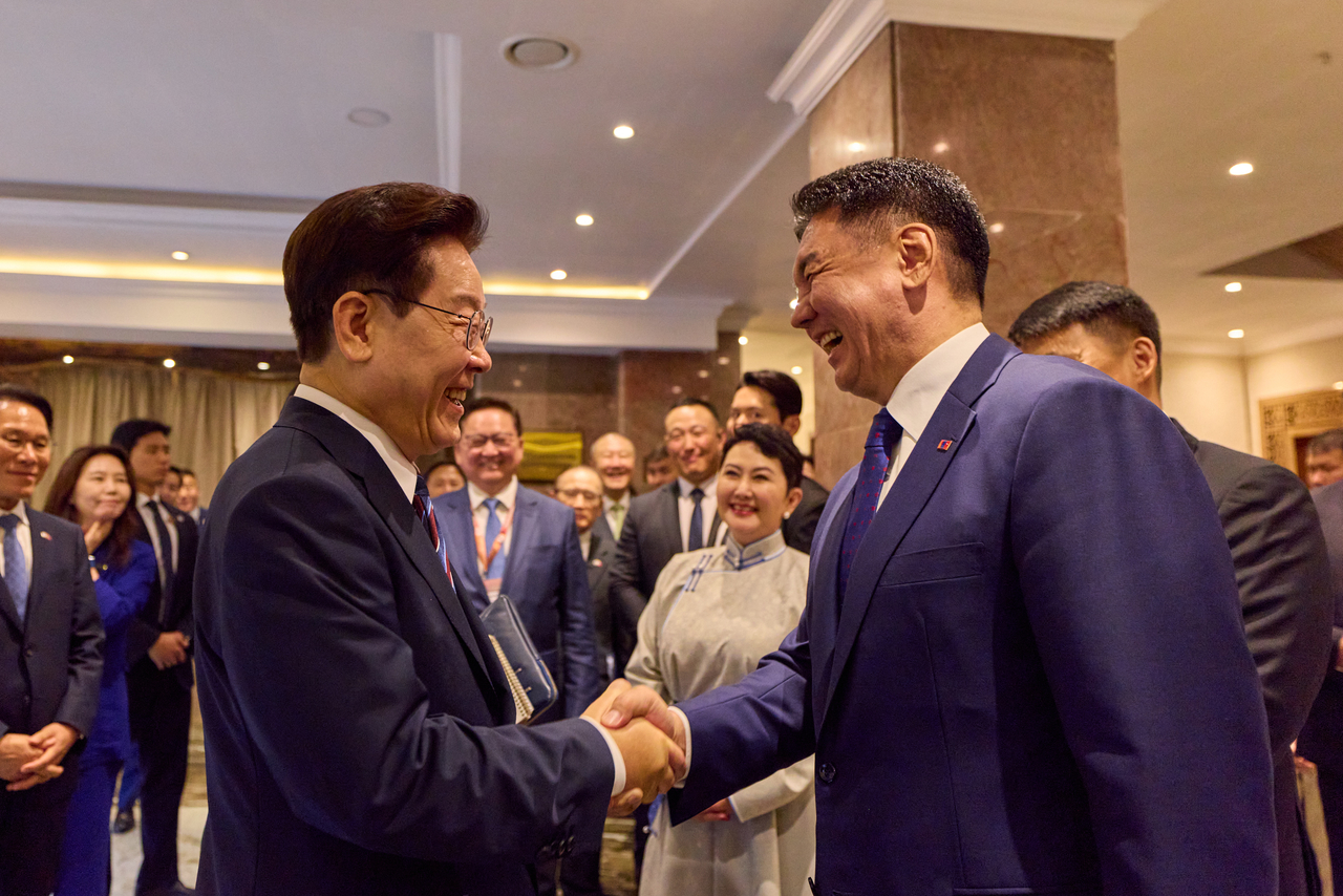 President Lee Jae Myung and Mongolian President Ukhnaagiin Khurelsukh exchange greetings after the Korea-Mongolia Business Forum at a hotel in Ulaanbaatar on Thursday. (Pool photo via Yonhap)