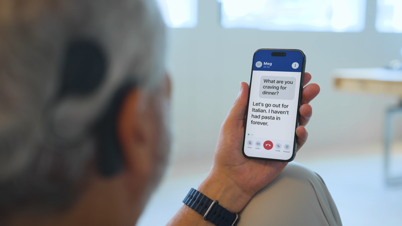 Real-time captions are displayed on the screen as two people speak on their phones. (InnoCaption)