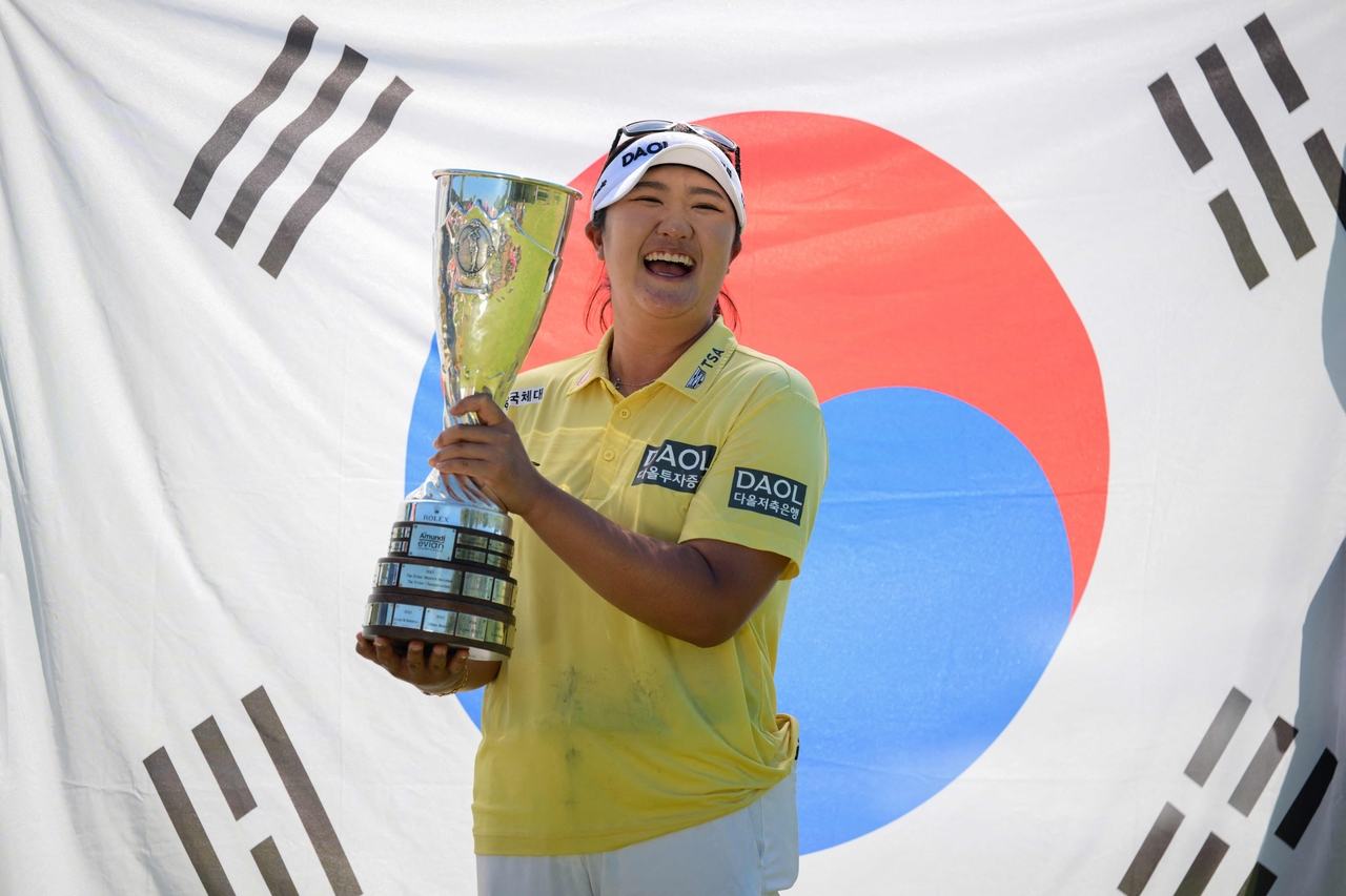 Ryu Hae-ran poses with the trophy in front of a South Korean flag after winning the Amundi Evian Championship at Evian Resort Golf Club, in Evian-Les-Bains, centre eastern France, Sunday.   AFP-Yonhap