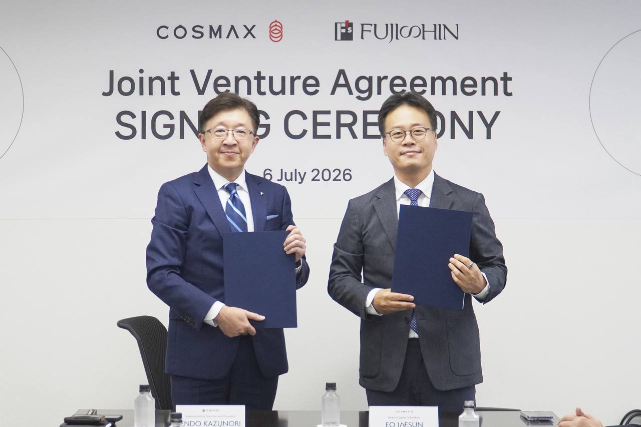 Endo Kazunori (left), CEO of Fujishin, and Eo Jason, head of Cosmax Japan, pose for a photo after signing a joint venture agreement in Tokyo on July 6. (Cosmax)