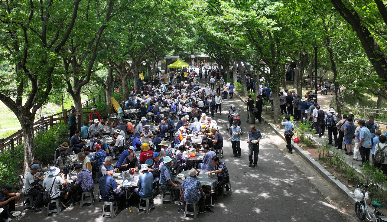 Senior residents enjoy free bowls of samgyetang at Duryu Park in Daegu on Tuesday. (Yonhap)