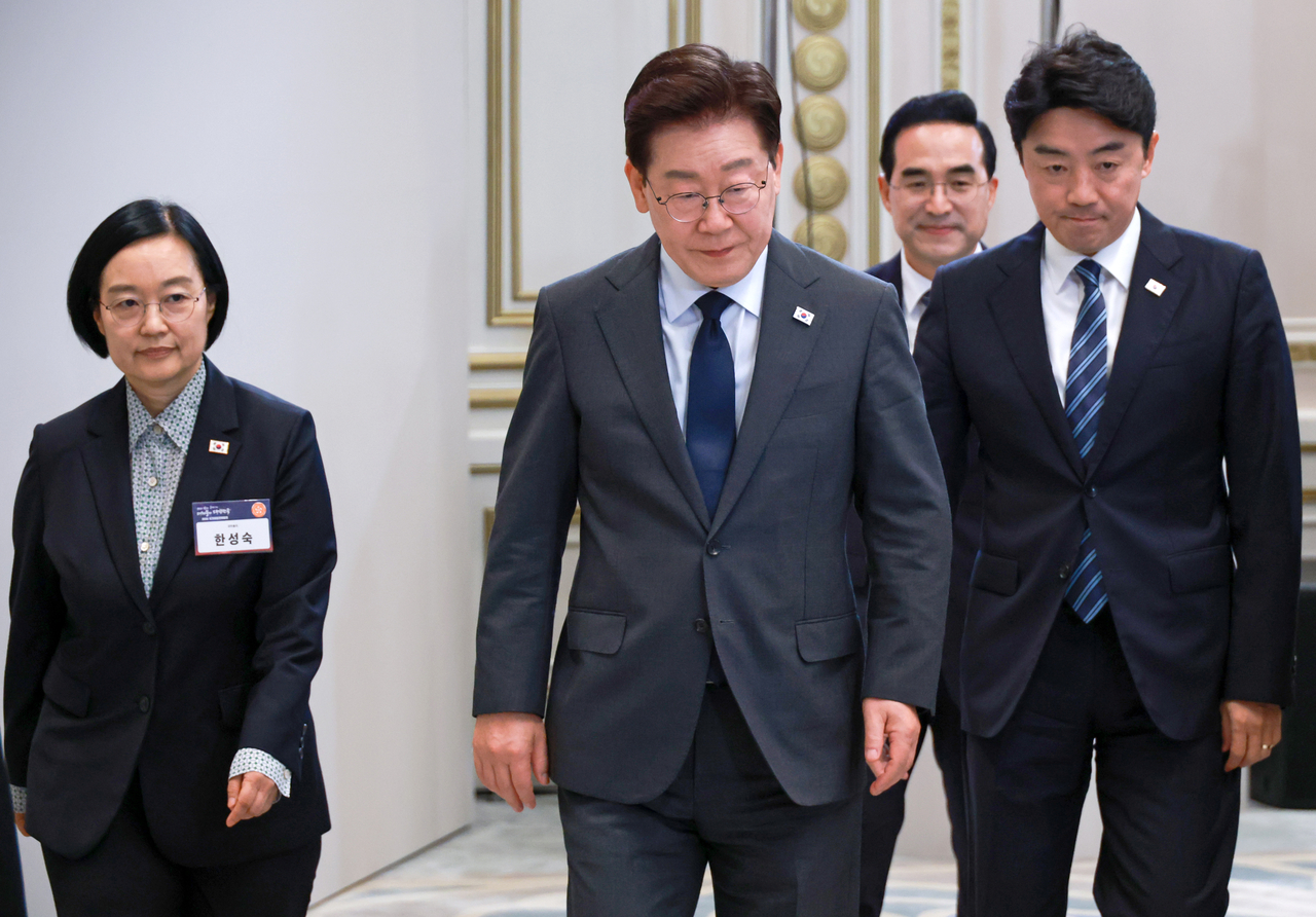 President Lee Jae Myung (C) and his chief of staff Kang Hoon-sik (R) attend a National Fiscal Strategy Meeting at the presidential office Cheong Wa Dae in Seoul on Monday. (Yonhap)