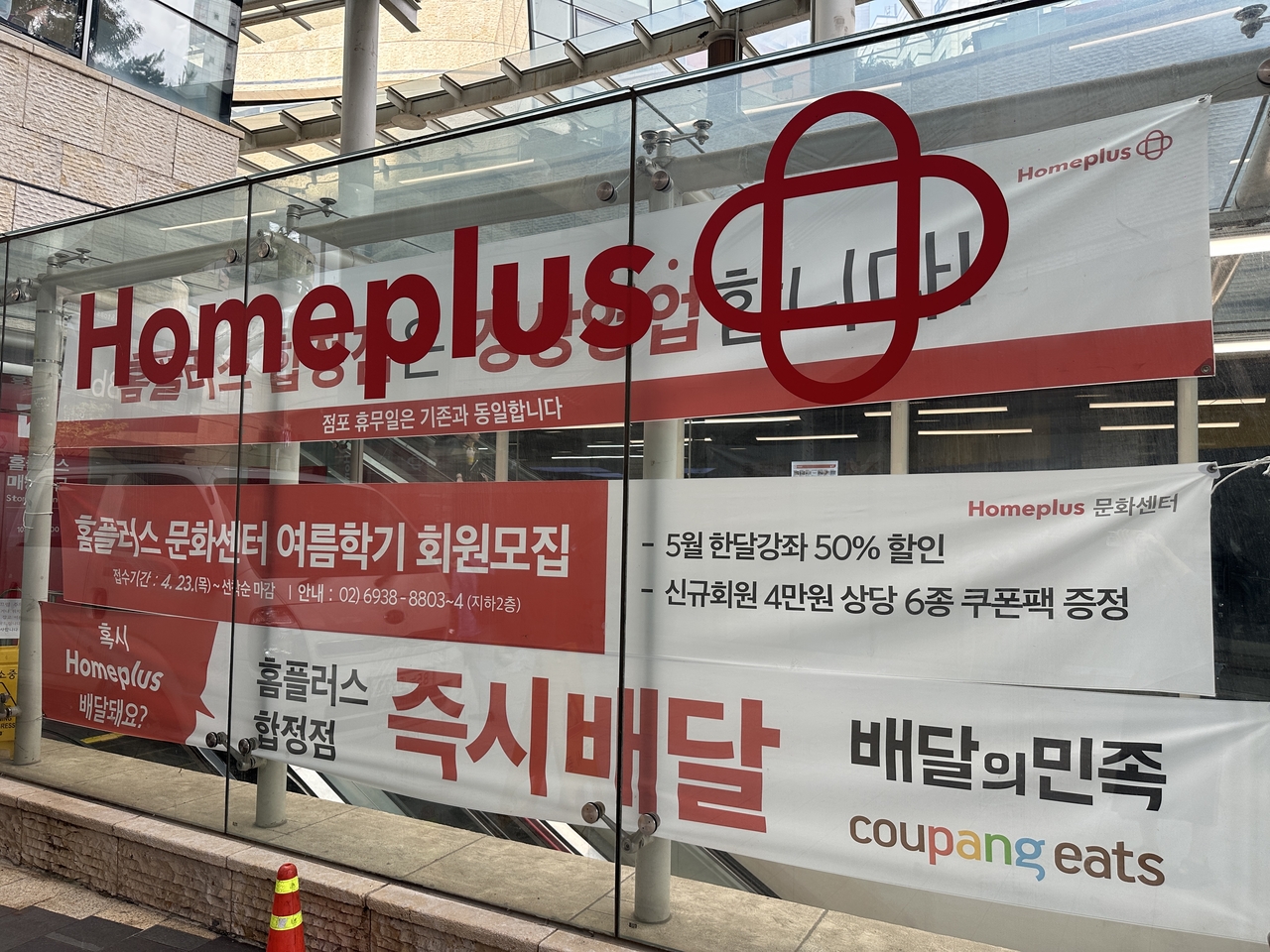 Banner advertising normal operations and culture center programs remain displayed outside of Homeplus Hapjeong branch in Seoul despite the retailer's temporary closure. (Tammy Park/The Korea Herald)