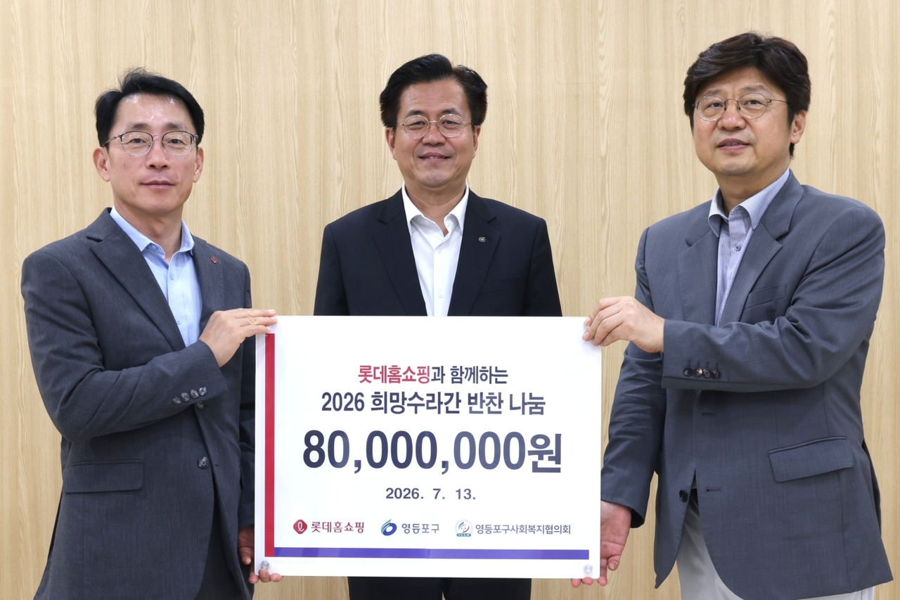 Kim Jae-gyeom (from left), CEO of Lotte Home Shopping, Yeongdeungpo-gu District Mayor Jo Yu-jin, and Park Yeong-jun, chairman of the Yeongdeungpo-gu Social Welfare Council, pose for a photo at the reopening ceremony for Huimang Suragan, a banchan-sharing cooking facility inside the Yeongdeungpo-gu Office annex, on Monday. [Lotte Department Store]