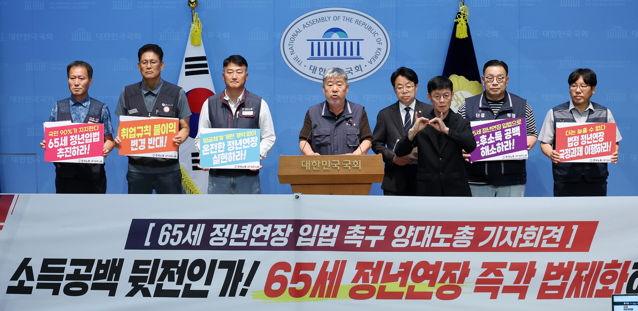 Federation of Korean Trade Unions Chairman Kim Dong-myeong (right) and Korean Confederation of Trade Unions Chairman Yang Gyeong-su call for legislation to raise the mandatory retirement age to 65 at a joint press conference at the National Assembly on June 16. [Yonhap]