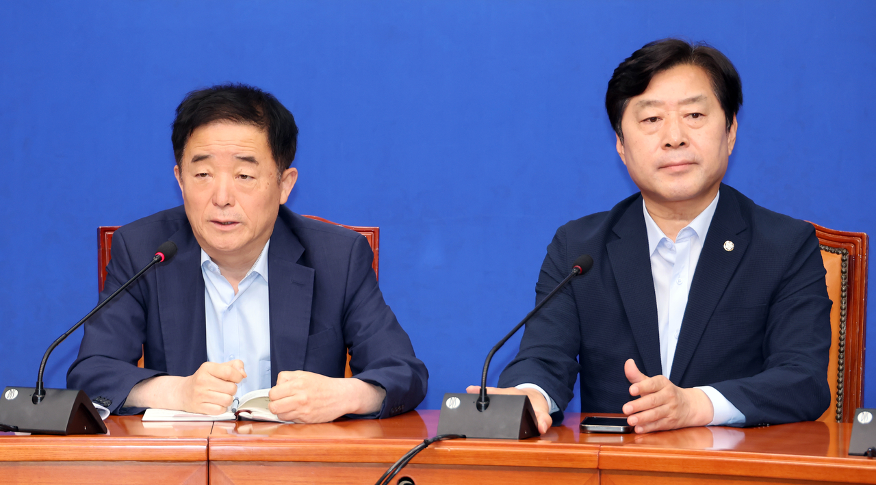 Democratic Party Reps. Kang Deuk-gu (left) and Hwang Myeong-seon is seen after the supreme council meeting held Tuesday. (Yonhap)