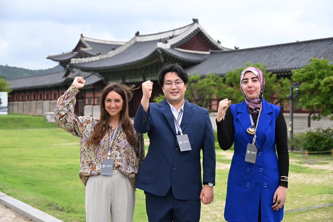 From left, Angela Puppini of Italy, Lee Jae-hoon of South Korea and Yasmein Abdo of Egypt, participants in the 2026 World Heritage Young Professionals Forum, pose for a group photo ahead of an interview with reporters at the National Palace Museum of Korea in Seoul on Monday. (Korea Heritage Service)