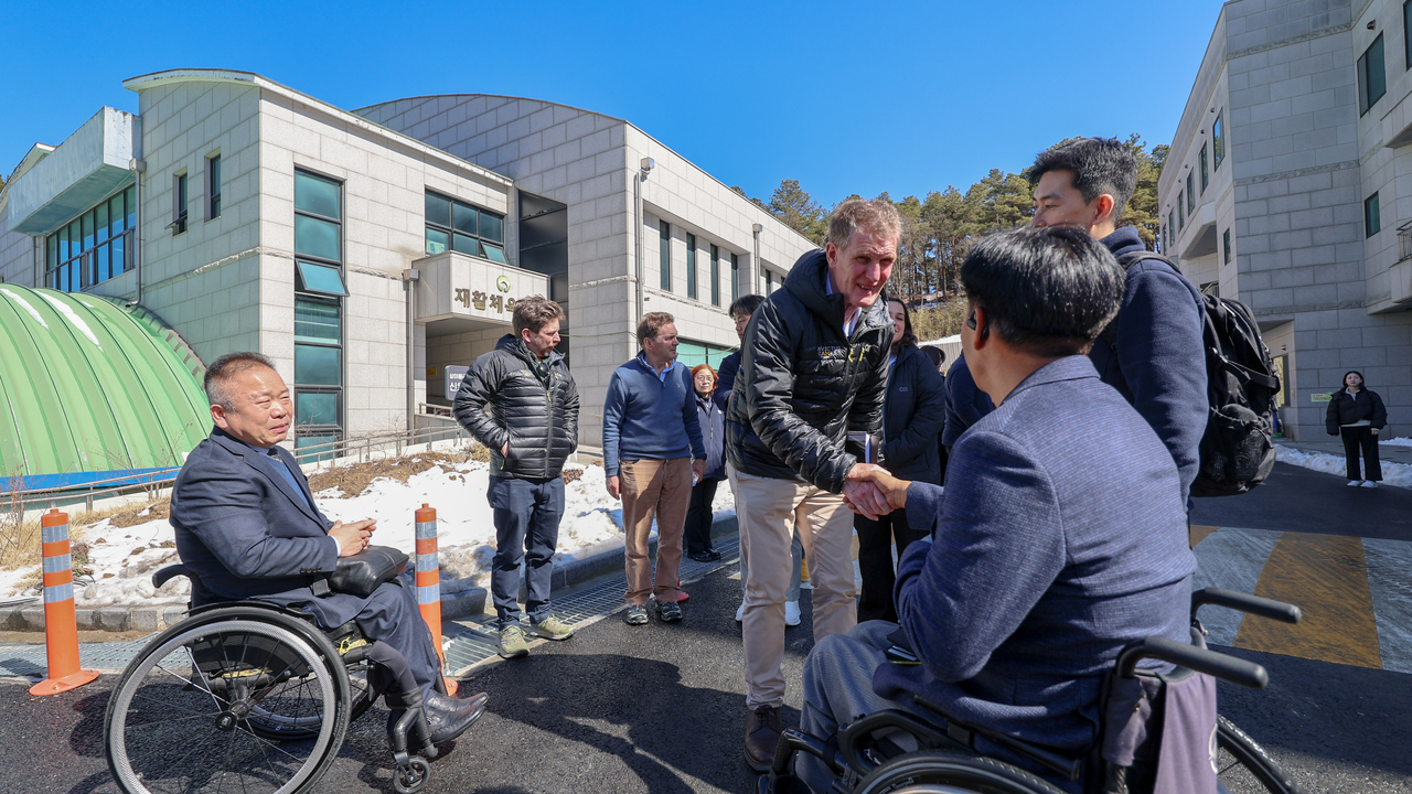 Richard Smith (center), deputy chief executive of the Invictus Games Foundation, shakes hands with Kwon Hyun-ju (right), head coach of South Korea’s national para archery team, alongside Jeong Eun-chang (left), head coach of the national para table tennis team, at Daejeon Veterans Hospital on Feb. 25. (Ministry of Patriots and Veterans Affairs)