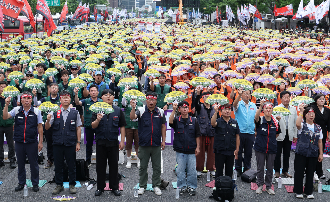 Participants wave fans and chant slogans at a general strike rally held by the Korean Confederation of Trade Unions (KCTU) near the Dong Hwa duty-free store in Jongno-gu, Seoul, on Wednesday. [Yonhap]
