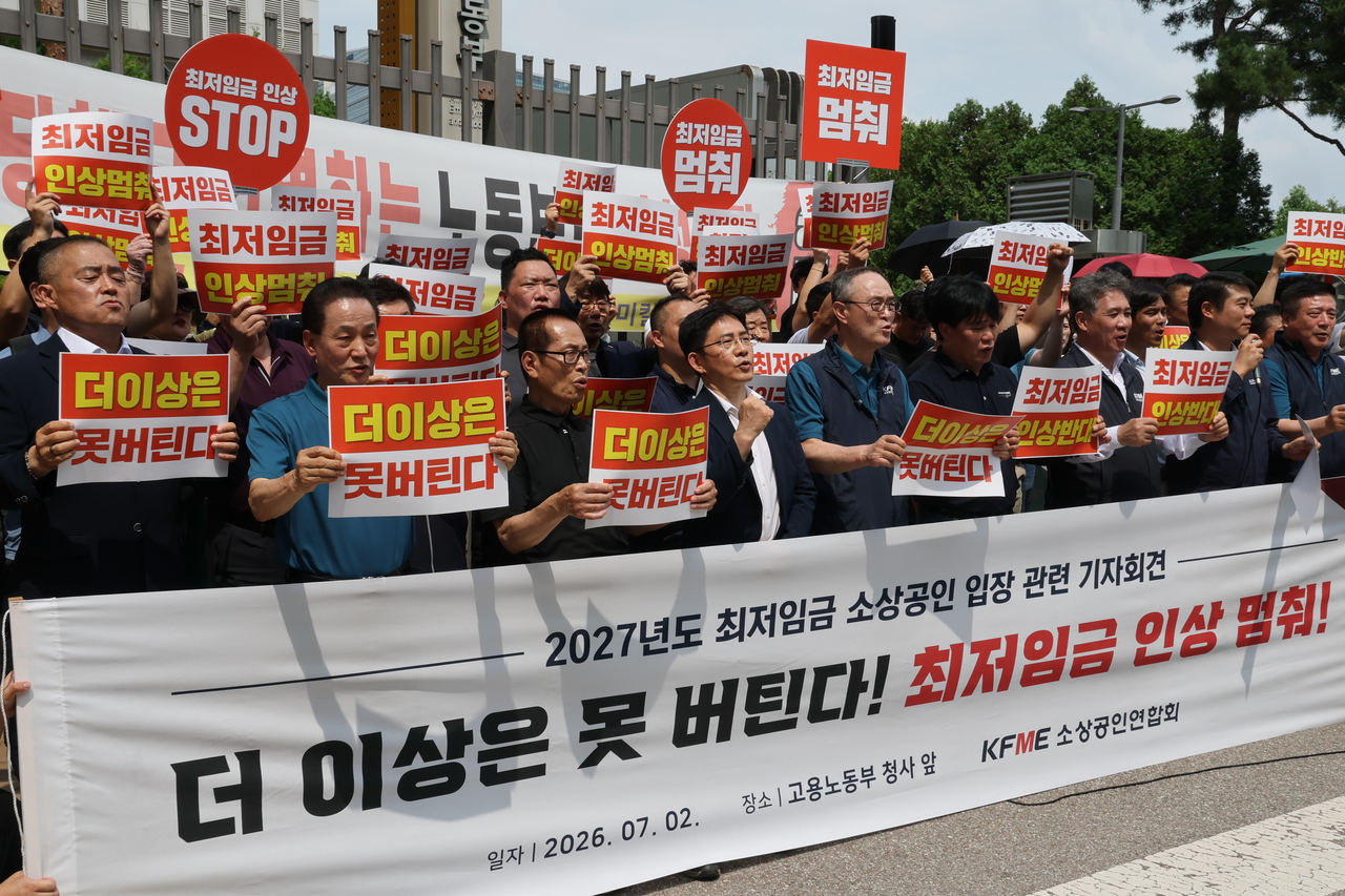 Members of the Korea Federation of Small and Medium Business Owners hold a press conference Tuesday in front of the Minimum Wage Commission at Government Complex Sejong to oppose a minimum wage increase for next year. Participants called for freezing next year's minimum wage at this year's level of 10,320 won per hour and urged the government to establish a legal basis for applying differentiated rates by industry. [Yonhap]