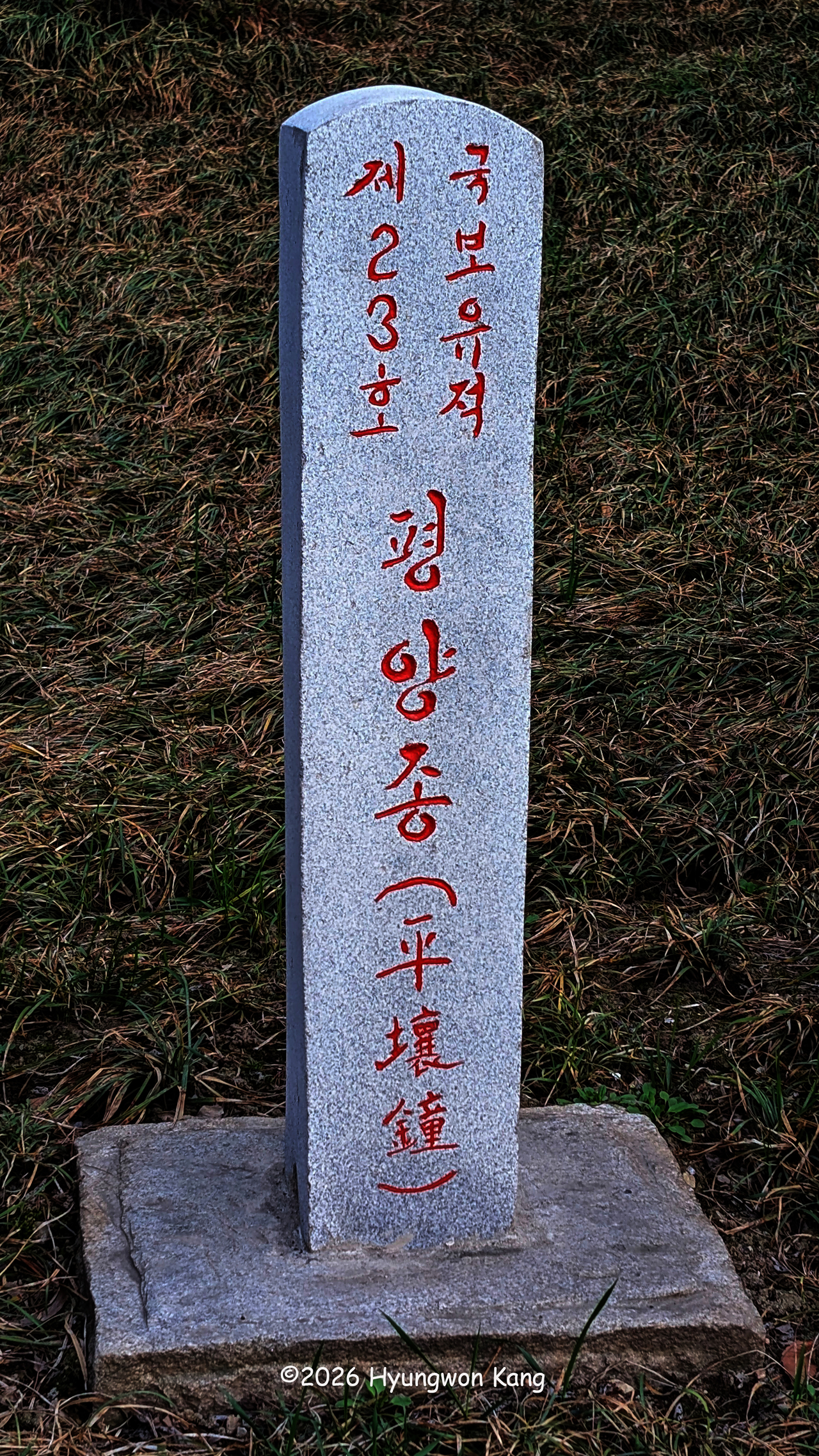 A stone marker identifying the Pyongyang Bell as National Treasure No. 23 stands along the Taedong River in Pyongyang. (Hyungwon Kang)