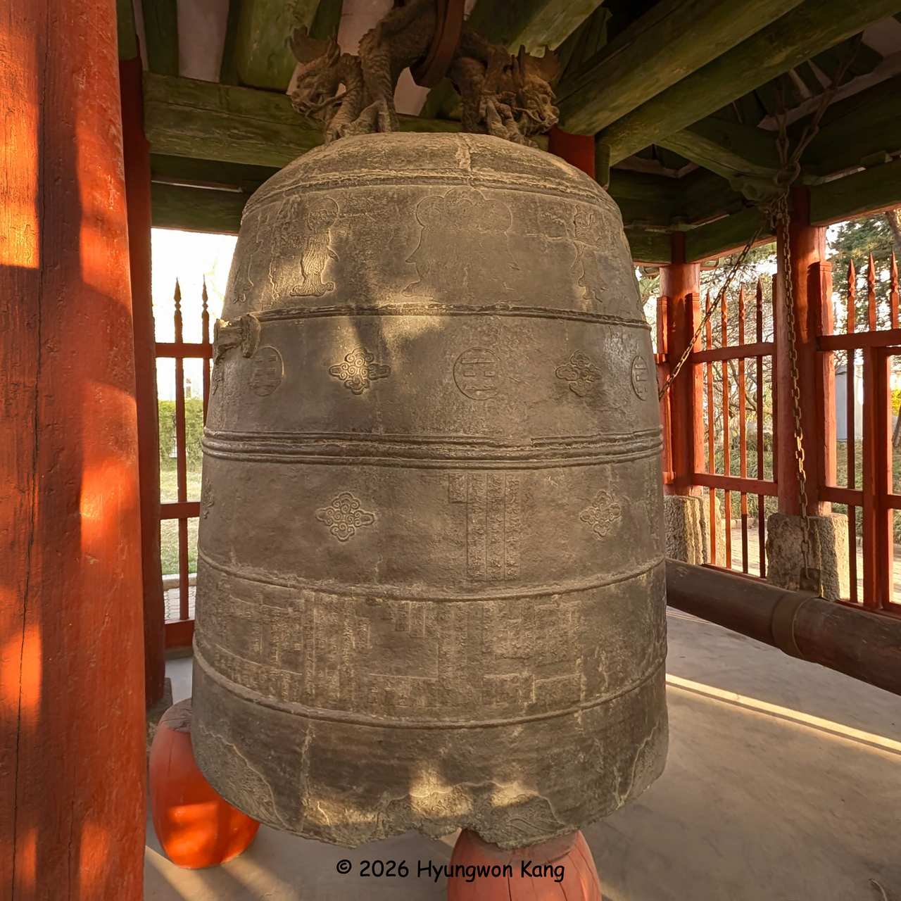 Cast in 1726, the Pyongyang Bell measures 3.1 meters high, 1.6 meters across its mouth, and weighs 12.9 tons. Unlike classical Silla bells, it has no cylindrical sound tube; two intertwined dragons form its suspension crown, and a continuous band of Eight Trigrams, or palgwae, encircles the bell. It is designated National Treasure No. 23. (Hyungwon Kang)
