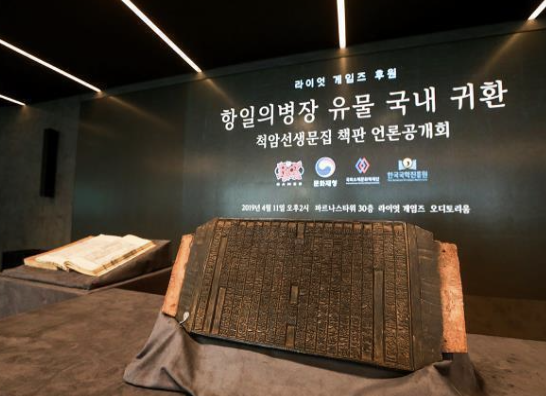 The Printing Woodblock of Cheokam Seonsaeng Munjip (left) is displayed during a press preview in Seoul in 2019. (Riot Games)