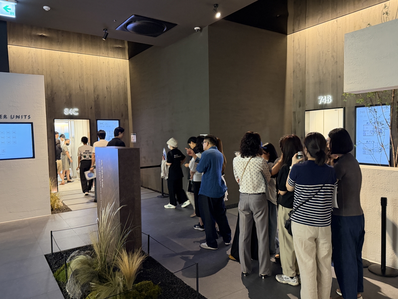 Visitors line up to enter a unit at the Jangwi Prugio Mark One model home. [Herald DB]