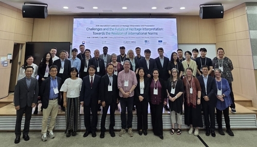 Participants pose for a group photo during the International Conference on World Heritage Interpretation on Friday. (Yonhap)