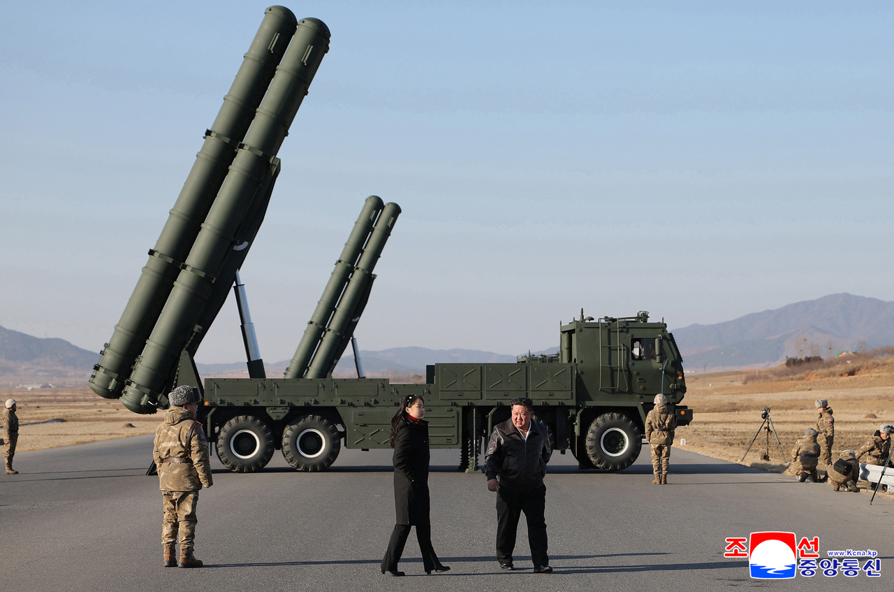 North Korean leader Kim Jong-un (center right) inspects the test-firing of an upgraded large-caliber multiple rocket launcher system on Jan. 27. (KCNA via Yonhap)