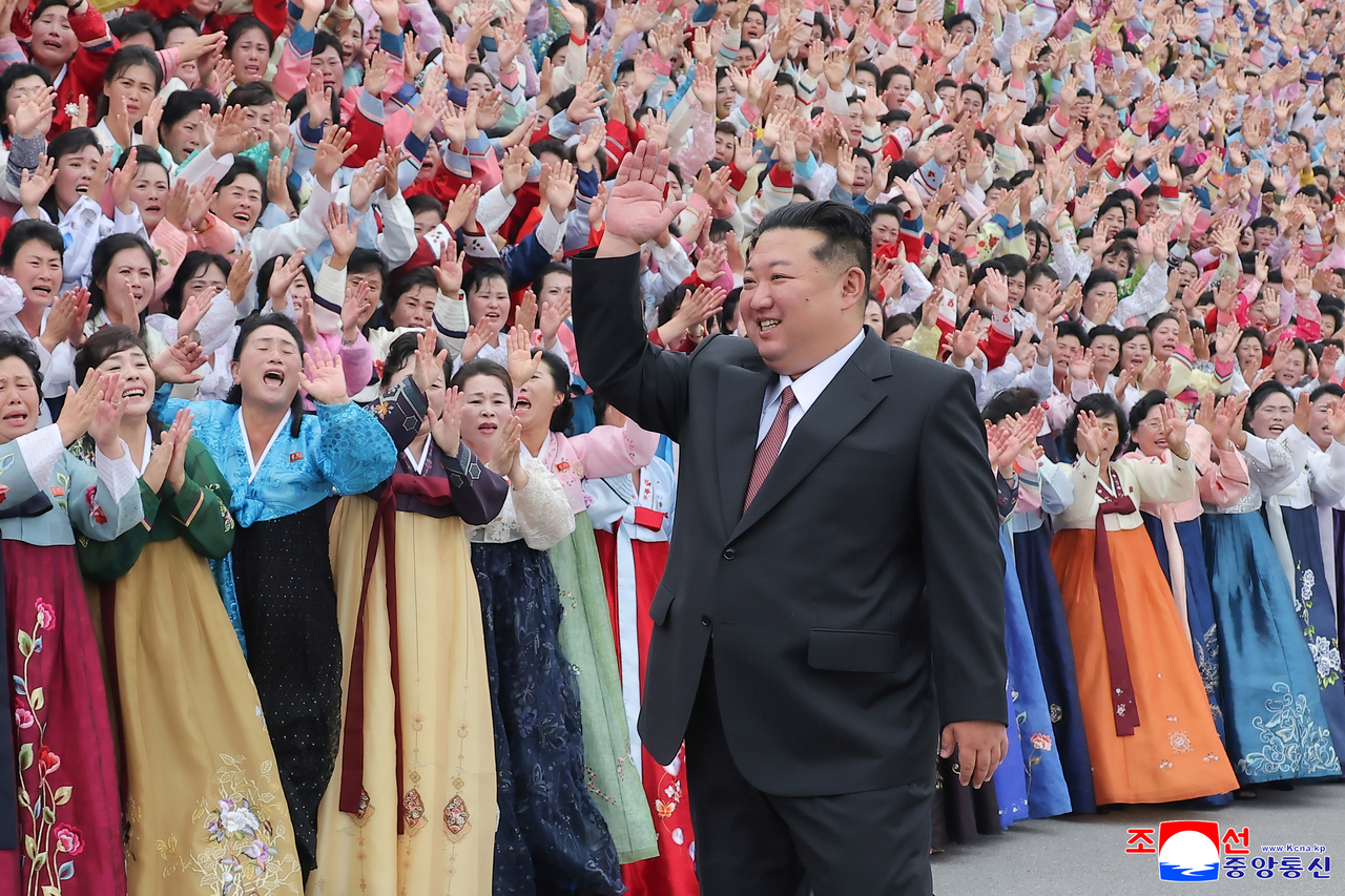 North Korean leader Kim Jong-un (center) waves at participants in a women's association meeting and members of a construction and engineering military unit on Friday. (KCNA-Yonhap)
