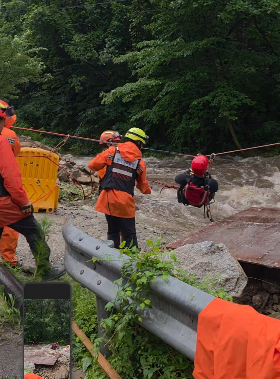 This photo shows fire authorities rescuing a man and a woman who were isolated due to rising water level in Inje, Gangwon Province on Saturday. (Courtesy of Gangwon Province Fire Headquarters)