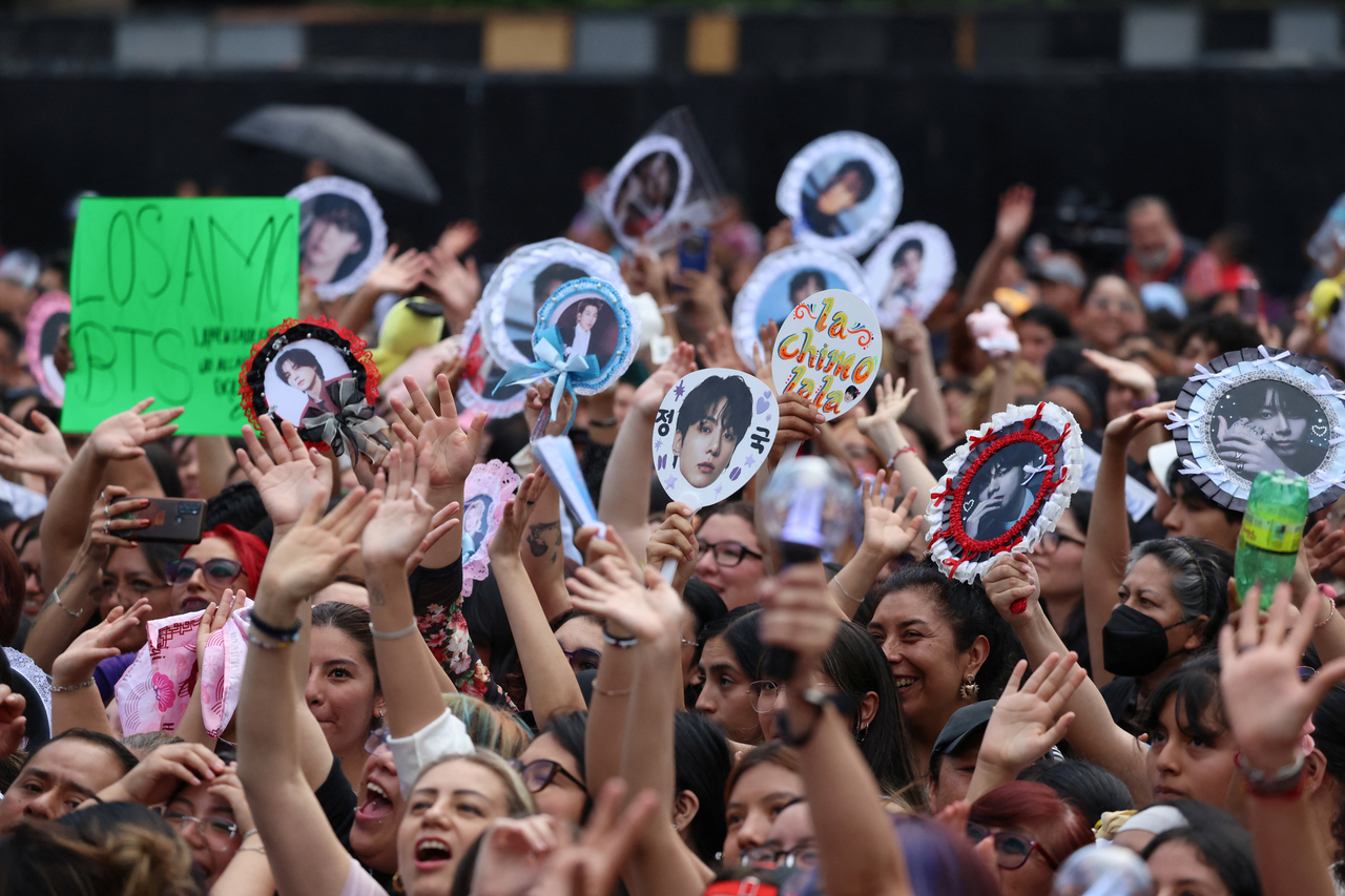 Fans hold up photos, posters and light sticks as BTS meets with Mexican president Claudia Sheinbaum at the National Palace ahead of the group's "Arirang" tour in Mexico City on May 6. (Reuters)