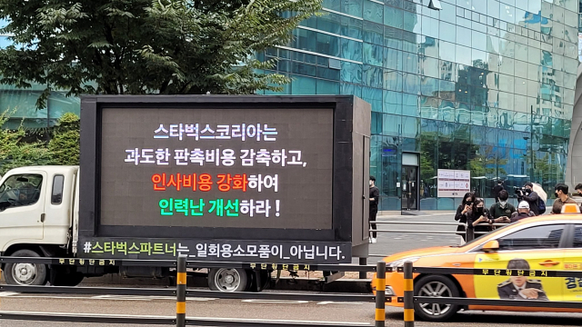 A truck displays a message calling on Starbucks Korea to reduce promotional spending and address staff shortages in Mapo-gu, Seoul, in 2021. (Screenshot from X)