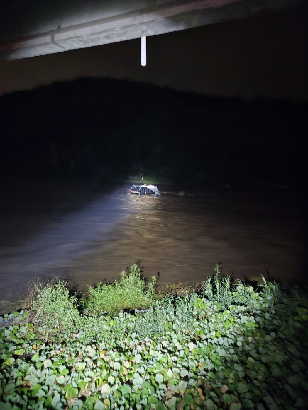 A camper is stranded by rising floodwaters at a recreational area in Andong, North Gyeongsang Province, on Saturday. The two persons, including the driver, were rescued by firefighters. (Yonhap)