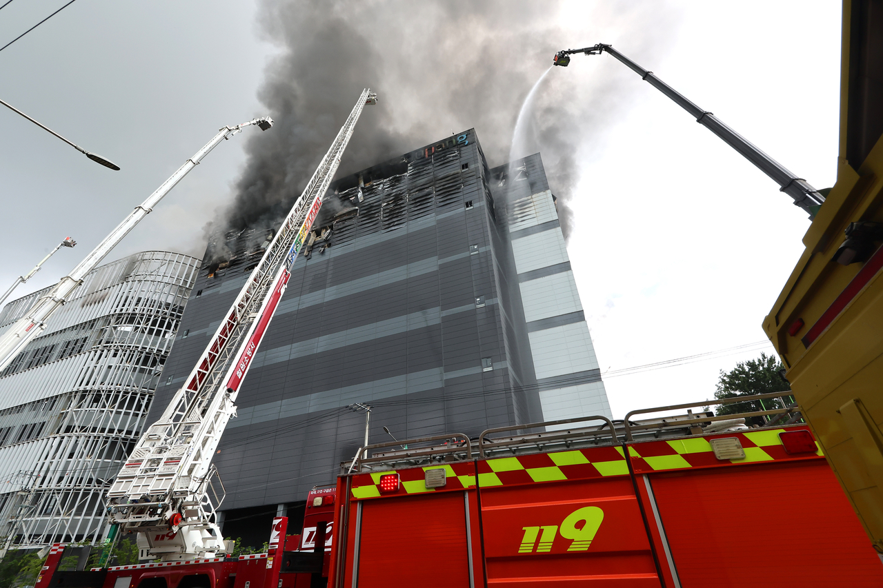 Fire department crews work to extinguish a blaze at a Coupang Inc warehouse in Incheon's Seo-gu on Sunday, the second consecutive day of firefighting operations. [Yonhap]