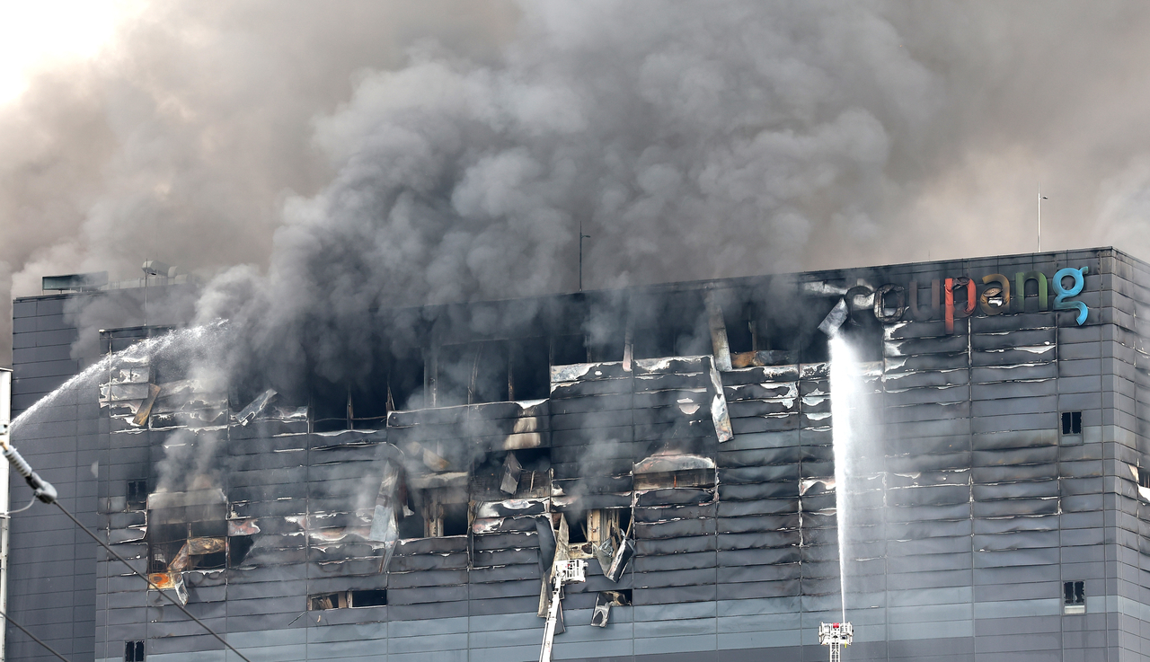Smoke billows from Coupang’s logistics center in Seoknam-dong, Seohae-gu, Incheon, on Sunday, more than a day after a fire broke out on the building’s sixth floor.  (Yonhap)