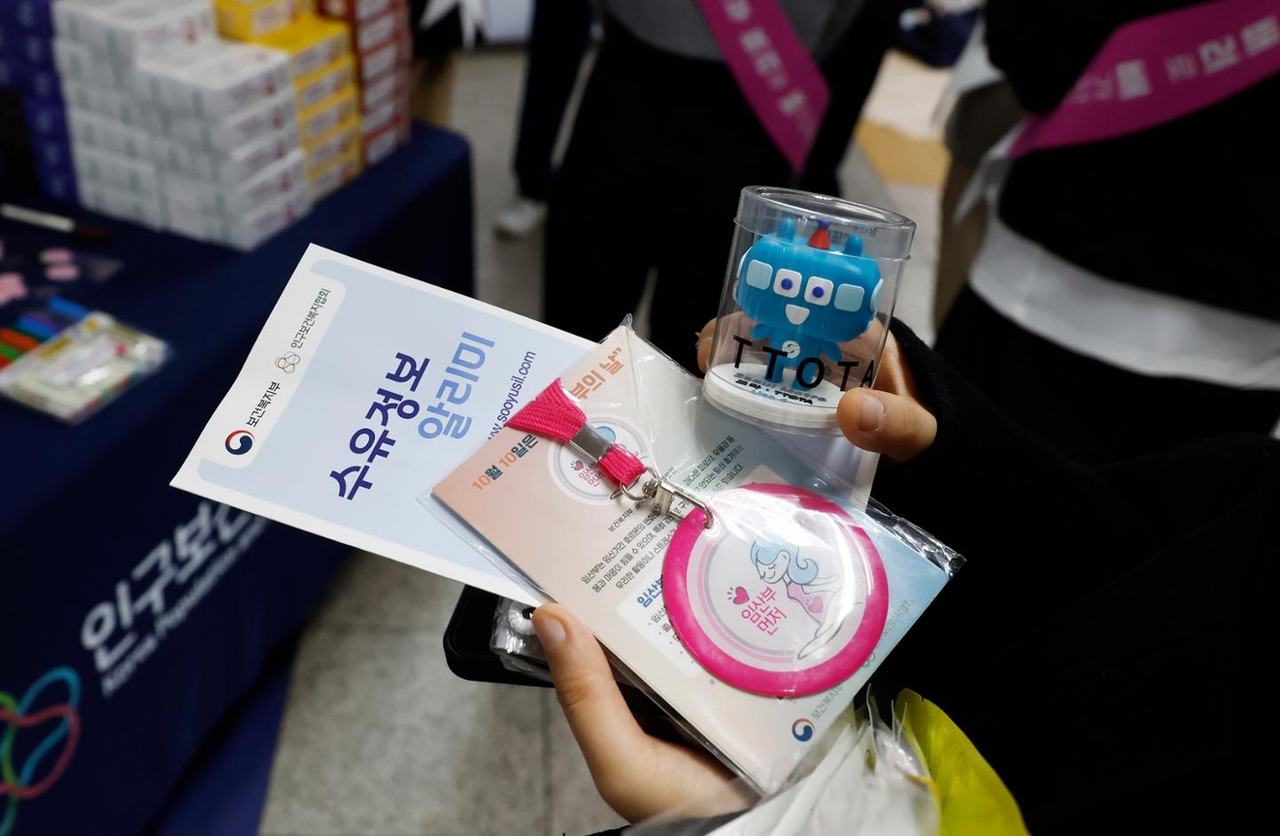 A pregnant woman holds a pink pregnancy badge at Yeouido Station in Seoul on April 28. (Newsis)