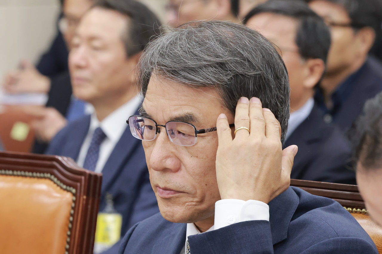 Former National Election Commission Chairperson Roh Tae-ak touches his hair during the first hearing of a National Assembly special committee investigating ballot shortages during the June 3 local elections, at the National Assembly building in Seoul on July 14. (Yonhap)
