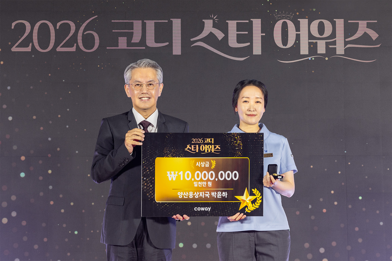 지난 20일 서울 용산구 그랜드 하얏트 서울 호텔에서 열린 ‘2026 코디 스타 어워즈’에서 ‘생산율 스타’ 1위를 수상한 박윤하 코디(오른쪽)가 서장원 코웨이 대표이사(왼쪽)와 함께 기념 촬영을 하고 있다. [코웨이]