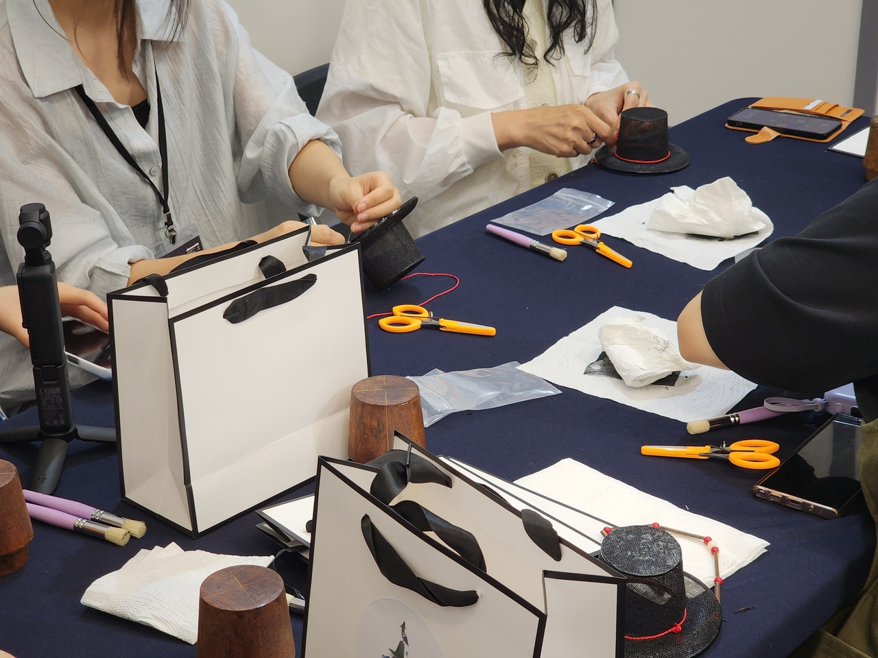 Visitors make miniature gat, traditional Korean horsehair hats, at the K-Heritage House during the 48th session of the UNESCO World Heritage Committee at Bexco in Busan on Monday. (Hwang Dong-hee/The Korea Herald)