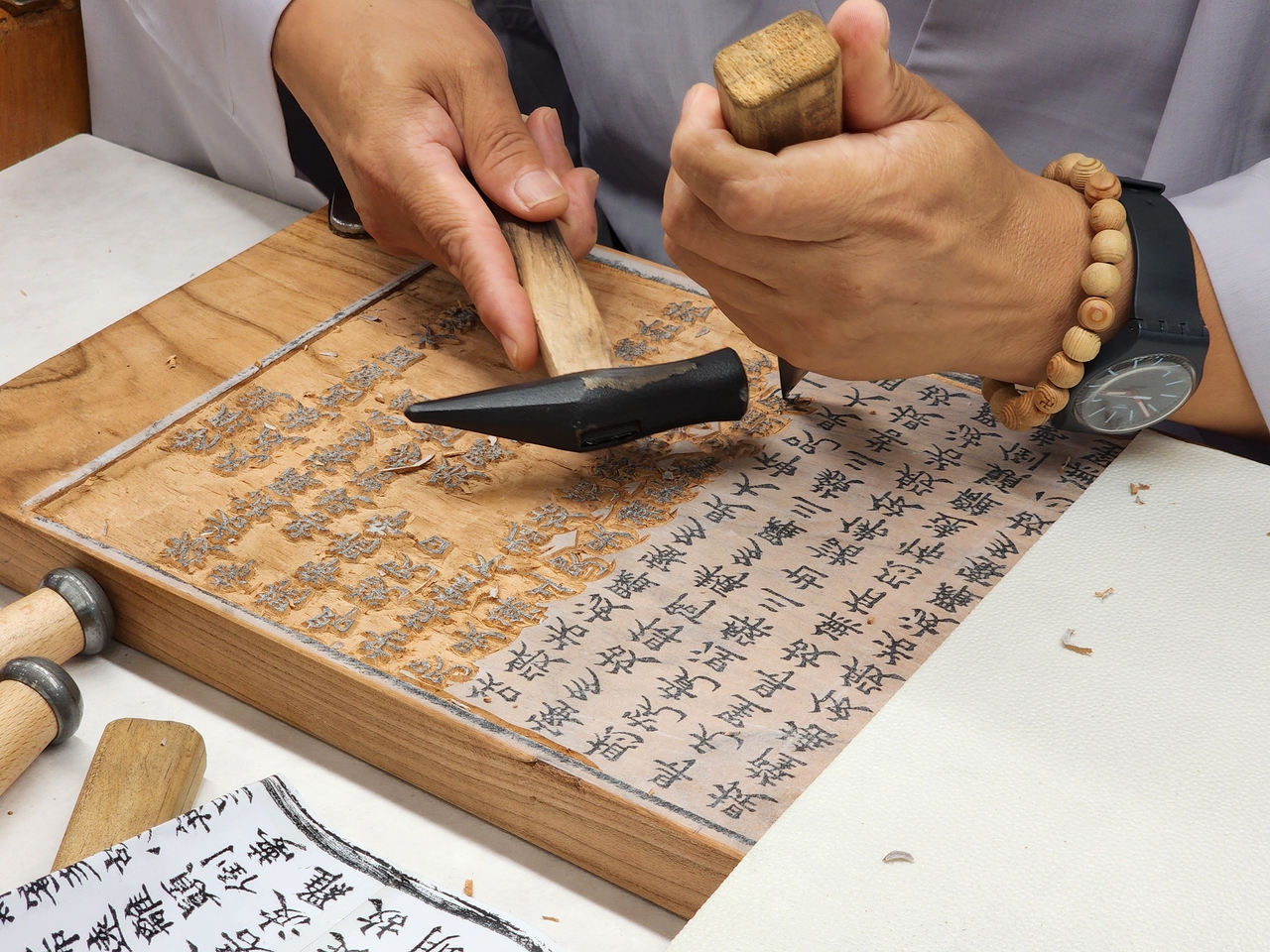 A Buddhist monk demonstrates the woodblock carving process at the K-Heritage House during the 48th session of the UNESCO World Heritage Committee at Bexco in Busan on Monday. (Hwang Dong-hee/The Korea Herald)