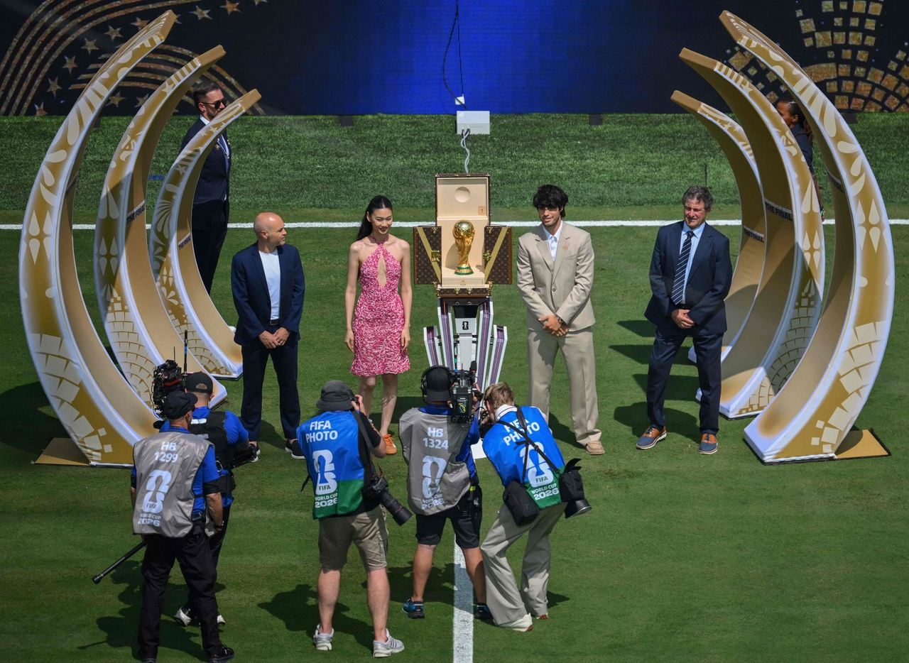 Former footballers Andres Iniesta of Spain (left) and Mario Kempes of Argentina (right) join Hoyeon and Spanish tennis player Carlos Alcaraz (center) during the FIFA World Cup trophy presentation ceremony ahead of the 2026 final between Spain and Argentina. (AFP)