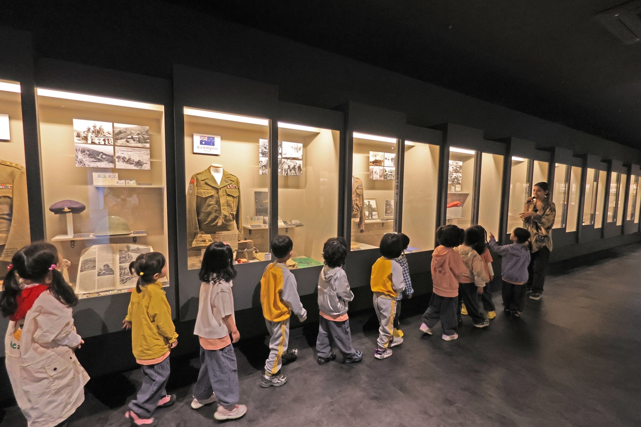 Sherry Nasrat (first from right), a 23-year-old Egyptian student at Pusan National University, guides a group of Korean children through an exhibition at the UN Peace Memorial Hall. (UN Peace Memorial Hall)