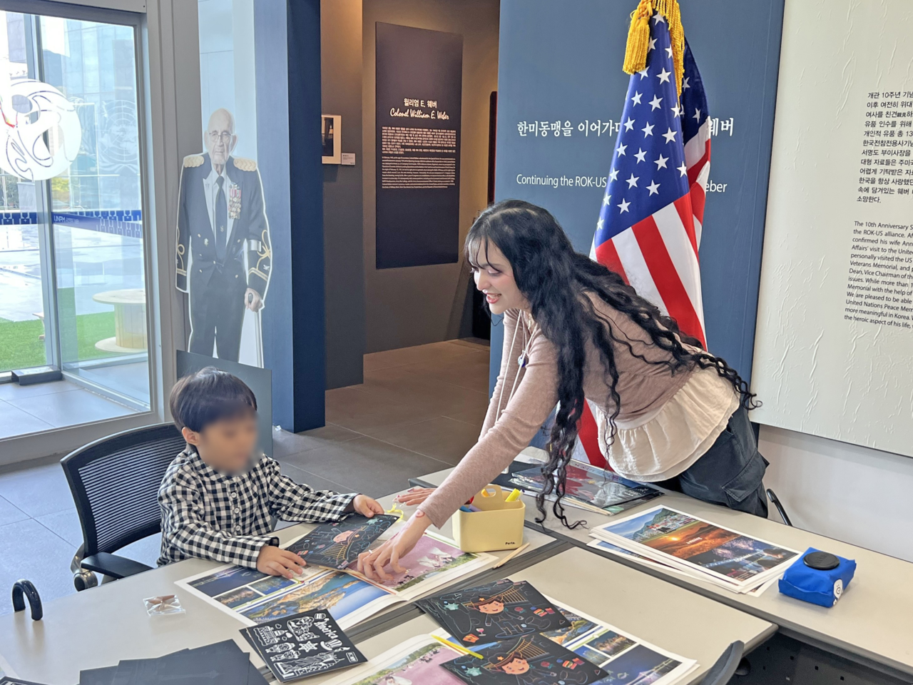 Carma Elharazi (right), a 25-year-old American student, teaches a Korean child about the US-South Korea alliance. (UN Peace Memorial Hall)