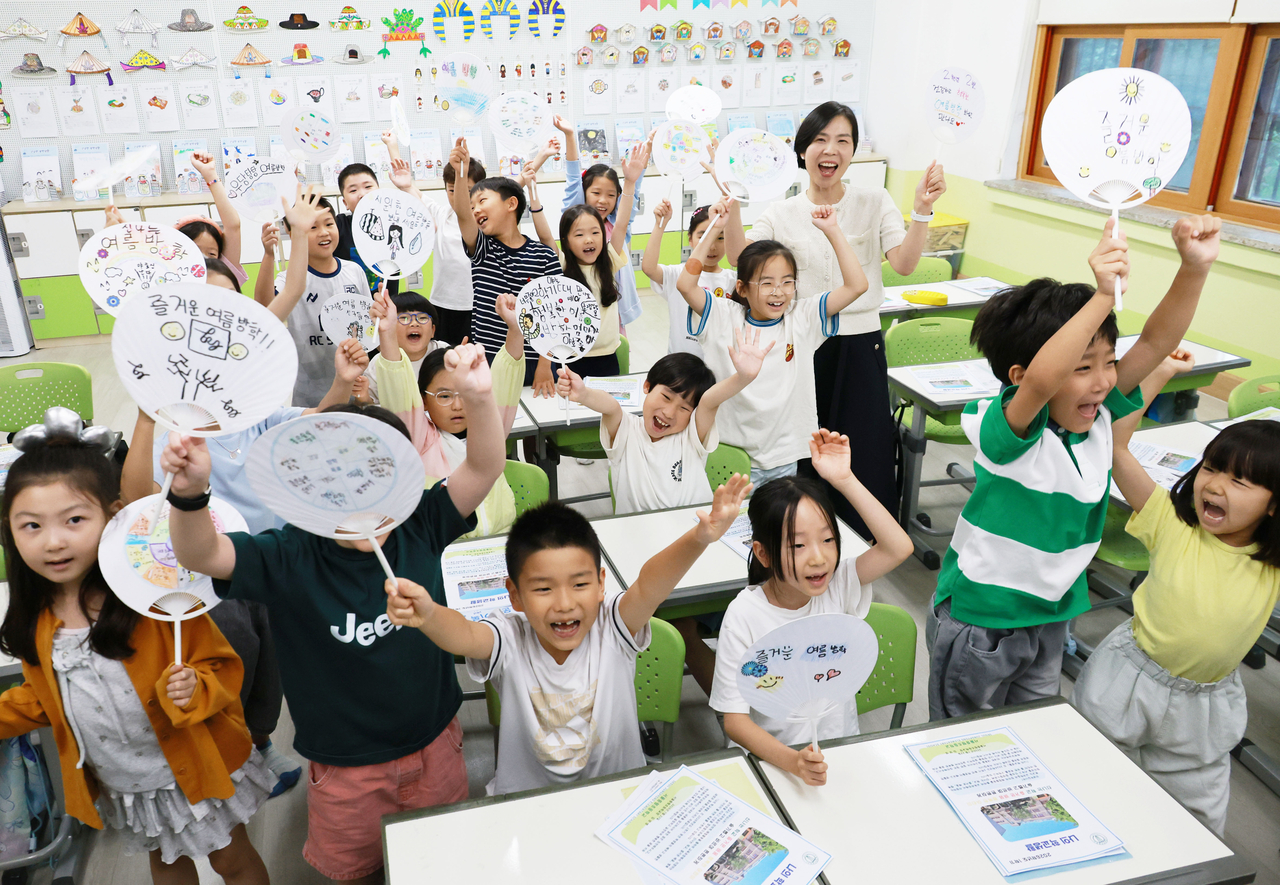 Second-grade students cheer with their teacher during a summer vacation ceremony at Jungpyeong Elementary School in Nowon-gu, Seoul, on Wednesday. (Yonhap)