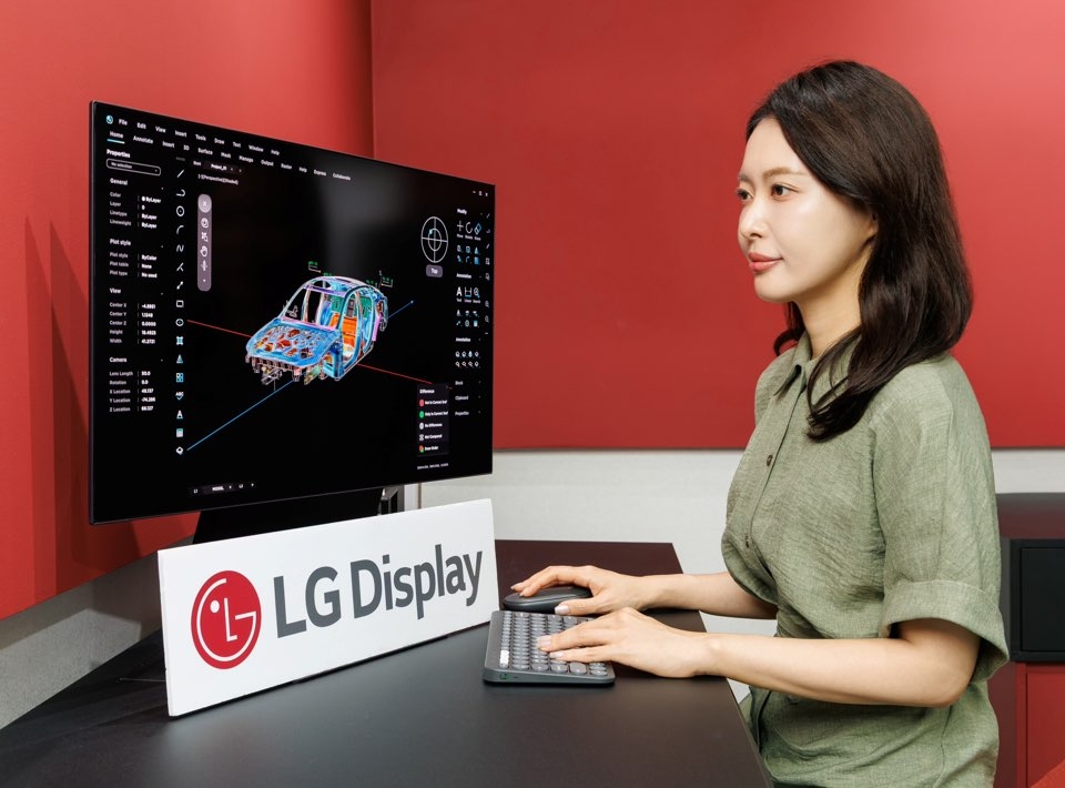 LG디스플레이 직원이 22일 서울 강남구 코엑스에서 열린 ‘K-디스플레이 2026’에서 ‘27인치 5K OLED 패널’을 체험하고 있다. [LG디스플레이 제공]