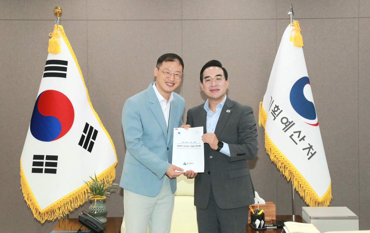 Ulsan Mayor Kim Sang-uk (left) hands documents outlining the city's key agenda items and proposed national budget projects to Planning and Budget Minister Park Hong-keun (right) at Government Complex Sejong on Wednesday. [Ulsan City]