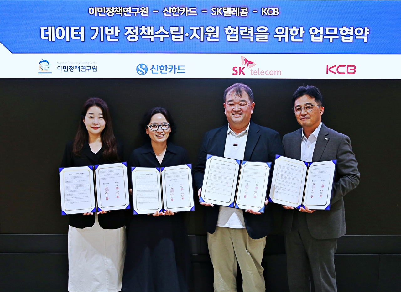김화연(왼쪽부터) 이민정책연구원 이민데이터센터장, 양수자 신한카드 데이터사업부장, 송훈환 SK텔레콤 AI Marketing사업팀장, 김종일 KCB 전략사업3부 담당이 기념사진을 촬영하고 있다. [신한카드 제공]