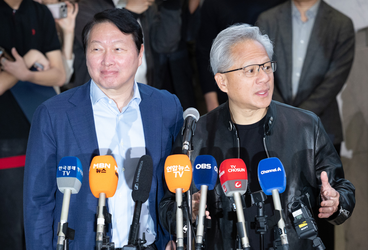 Nvidia CEO Jensen Huang  (right)speaks to reporters with SK Group Chairman Chey Tae-won at SK's Seorin Building in central Seoul on June 8, after the two met to outline an expanded memory and AI infrastructure partnership. (Yoon Chang-bin/The Korea Herald)