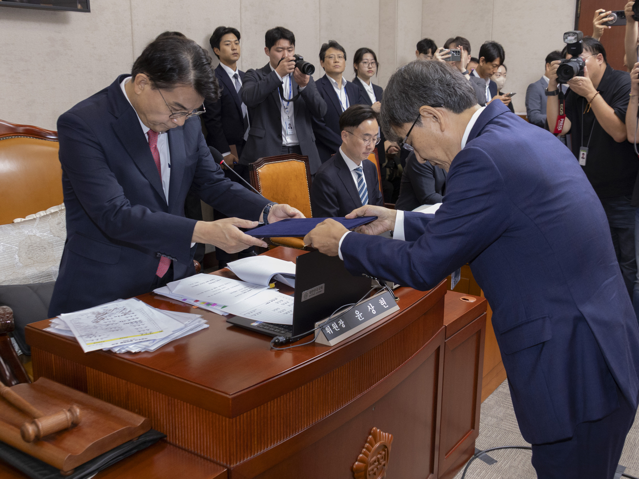 노태악(오른쪽) 전 중앙선거관리위원장이 22일 국회에서 열린 ‘투표용지 부족 사태 국정조사 특별위원회’ 제2차 청문회에 출석해 증인 선서를 마친 뒤 윤상현 위원장에게 선서문을 제출하고 있다.  [연합]