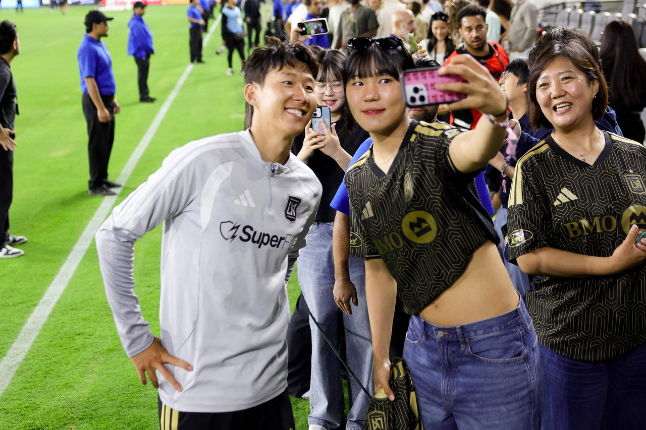 Son Heung-Min (left) of Los Angeles FC and Park Ji-Hyun of WNBA's Los Angeles Sparks take a selfie after a match against Real Salt Lake, at BMO Stadium in Los Angeles, Wednesday.   (AFP-Yonhap)