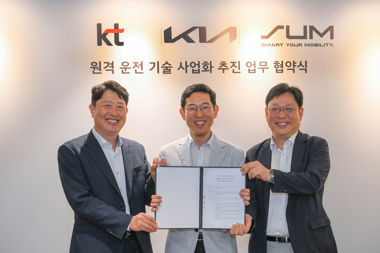 23일 서울 양재동 기아 본사에서 서상규(왼쪽부터) KT 기업사업1담당 상무, 강주엽 기아 신사업기획실 상무, 현영진 에스유엠 대표가 ‘원격 운전 기술 사업화 추진을 위한 업무협약(MOU)’을 체결하고 기념사진을 촬영하고 있다. [기아 제공]