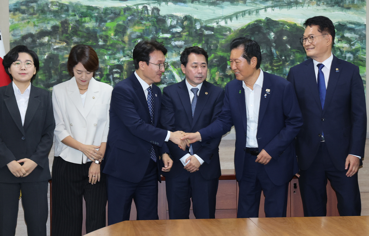 지난 21일 서울 중구 서울시의회에서 열린 더불어민주당 당대표 후보자 초청 간담회에서 김민석·정청래 후보가 악수하고 있다. [연합]