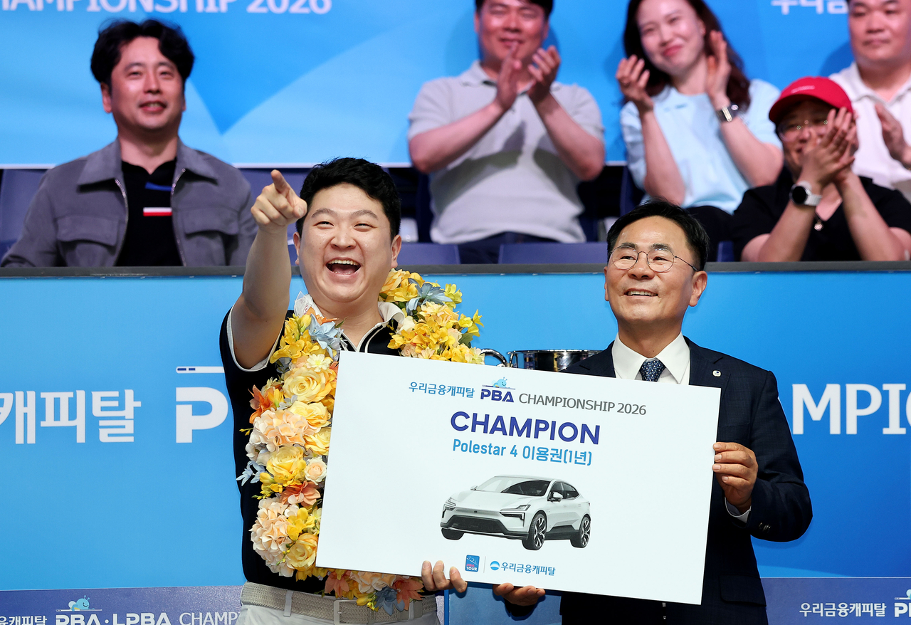 조건휘(왼쪽)가 지난 5월 ‘우리금융캐피탈 PBA 챔피언십 2026’ 우승 후 진행된 기념 사진에서 부상 폴스타 4 1년 이용권 판넬을 받고 있다. 오른쪽은 우리금융캐피탈 기동호 대표.