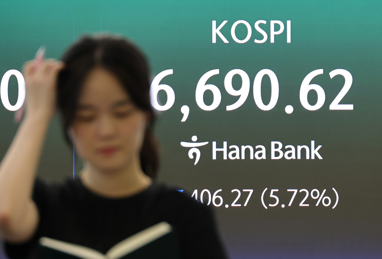 Employees at Hana Bank's headquarters in Seoul monitor stock markets and exchange rates on Friday, as both the Kospi and Kosdaq posted sharp losses. [Yonhap]