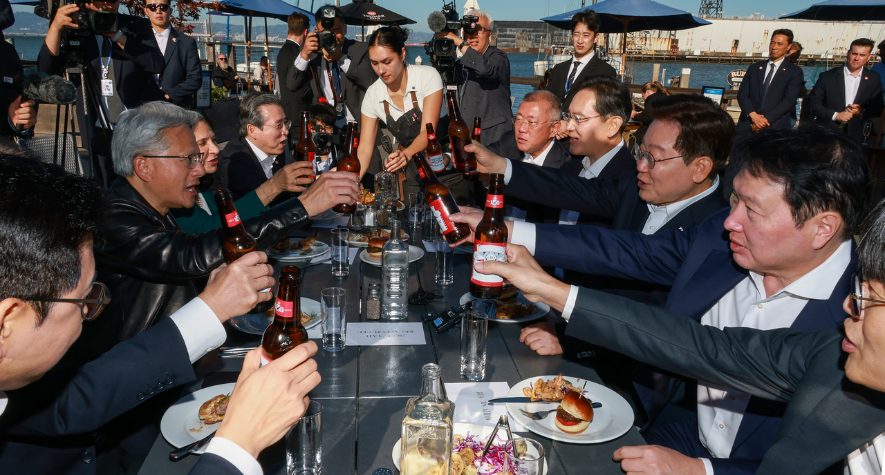 President Lee Jae Myung raises a toast with attendees at a dinner for global AI leaders at The Ramp restaurant in San Francisco on Friday. From right are Naver founder and board Chair Lee Hae-jin, SK Group Chair Chey Tae-won, President Lee, Samsung Electronics Executive Chair Lee Jae-yong, Hyundai Motor Group Executive Chair Chung Euisun, presidential policy chief Kim Yong-beom, Rani Borkar, president of Azure Hardware Systems and Infrastructure at Microsoft, Nvidia CEO Jensen Huang and Deputy Prime Minister and Science and ICT Minister Bae Kyung-hoon. (Yonhap)